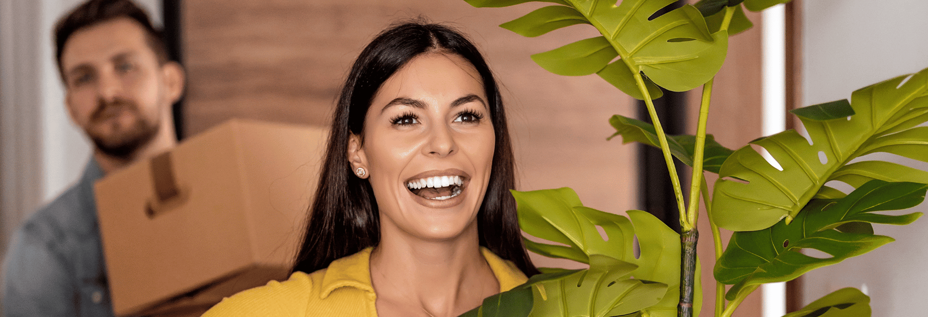 Lachende vrouw die een plant tilt