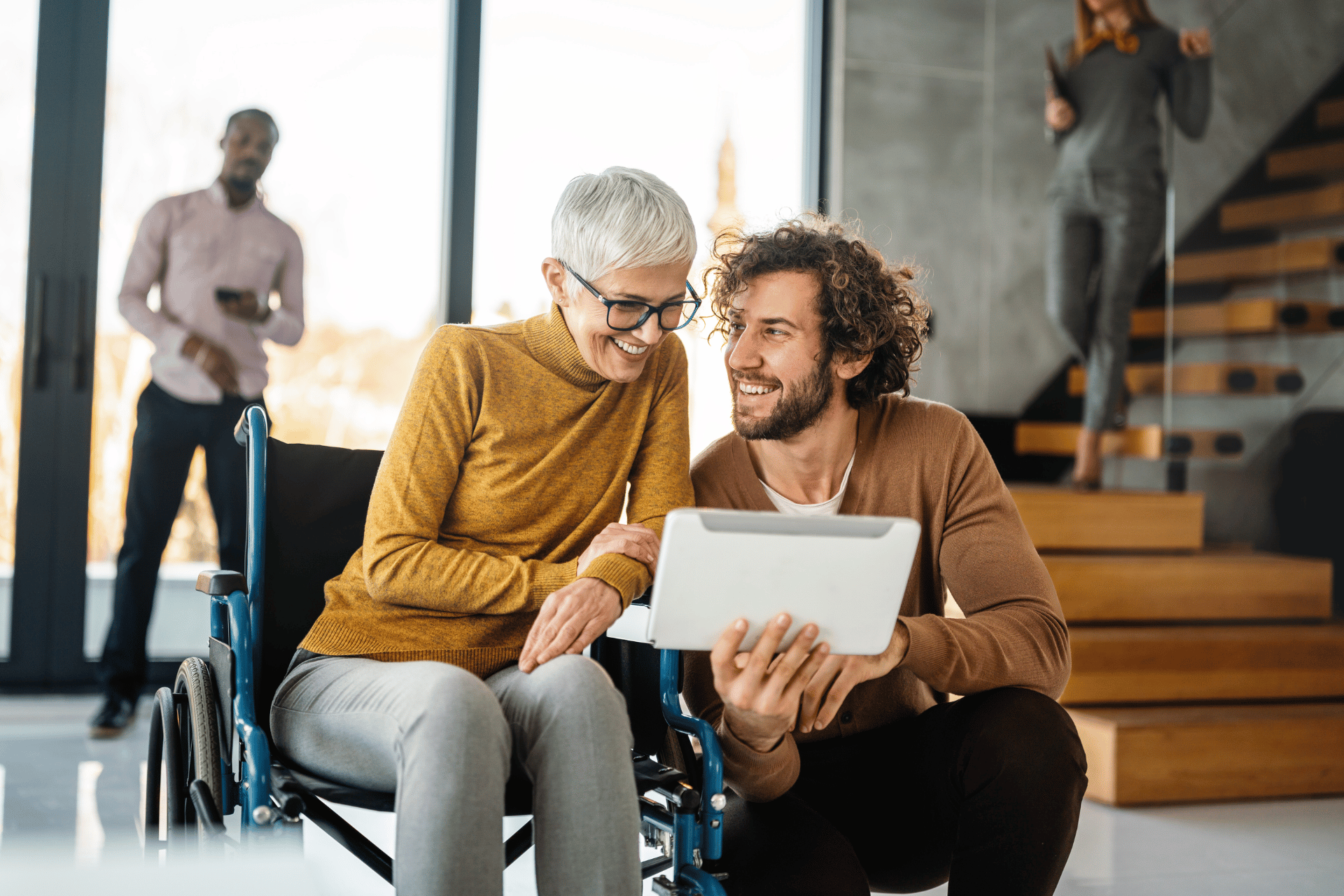 two colleagues smiling and looking at tablet