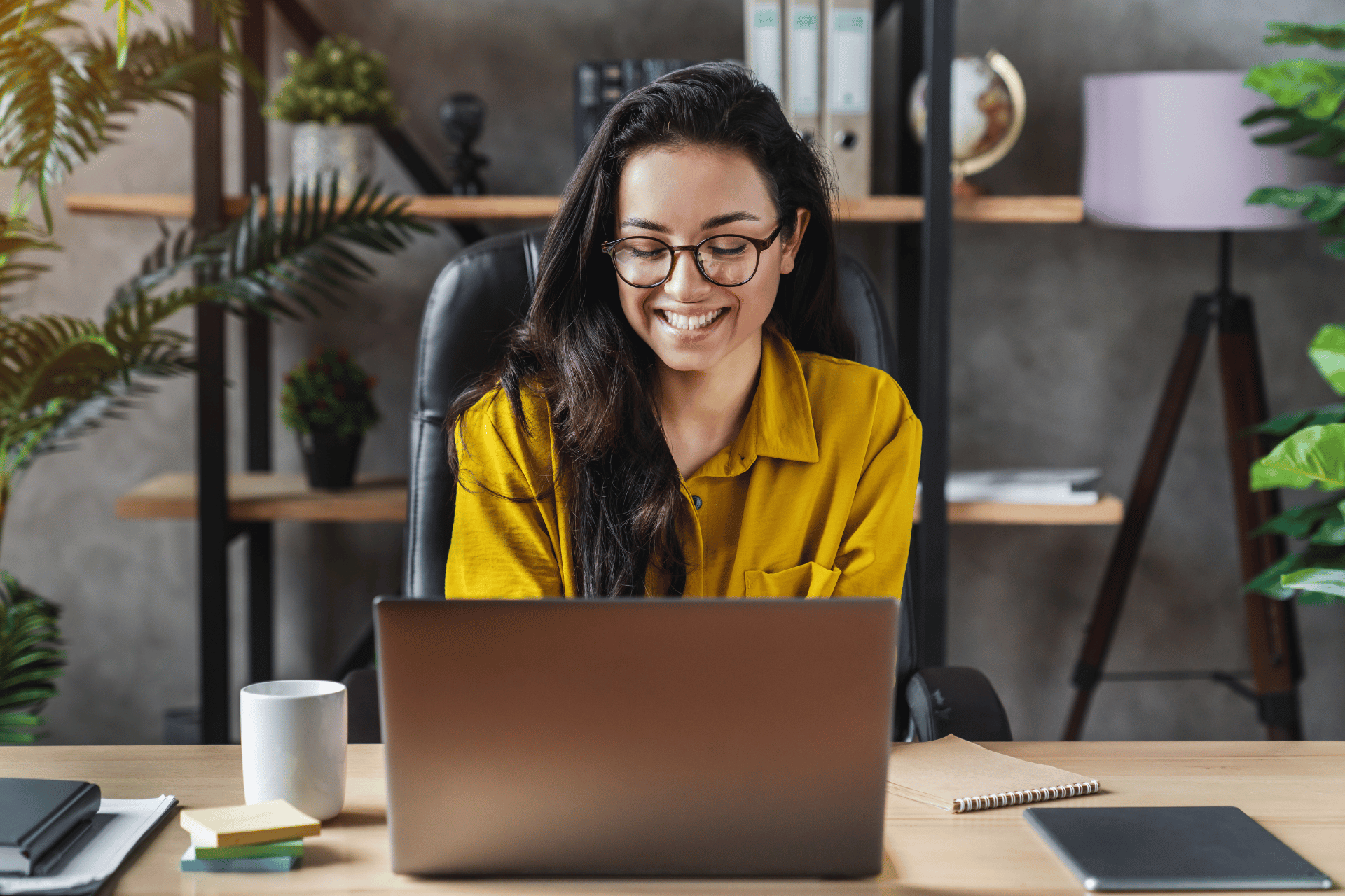 woman smiling behind laptop